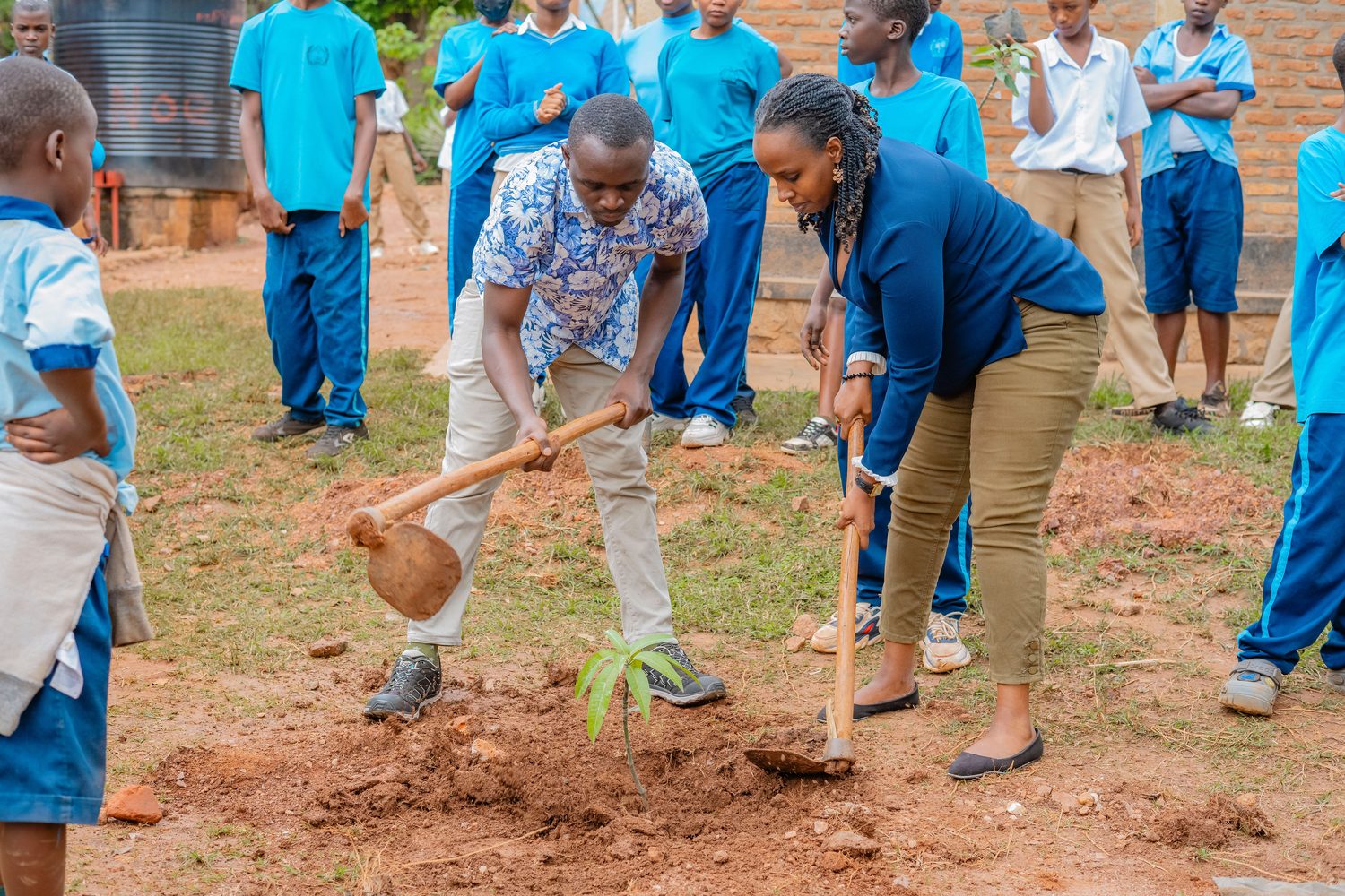 QS Impact leaders and students planting a tree at Kimisange Secondary School